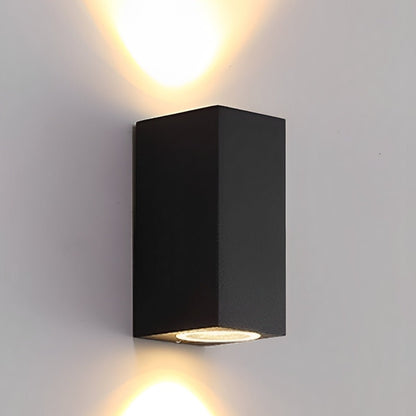 Svart rektangulär vägglampa som lyser både uppåt och nedåt på en ljus vägg 3