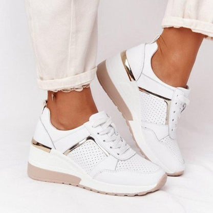 Weiße Damen-Sneaker mit Keilabsatz, perforiertem Design und goldenen Akzenten.