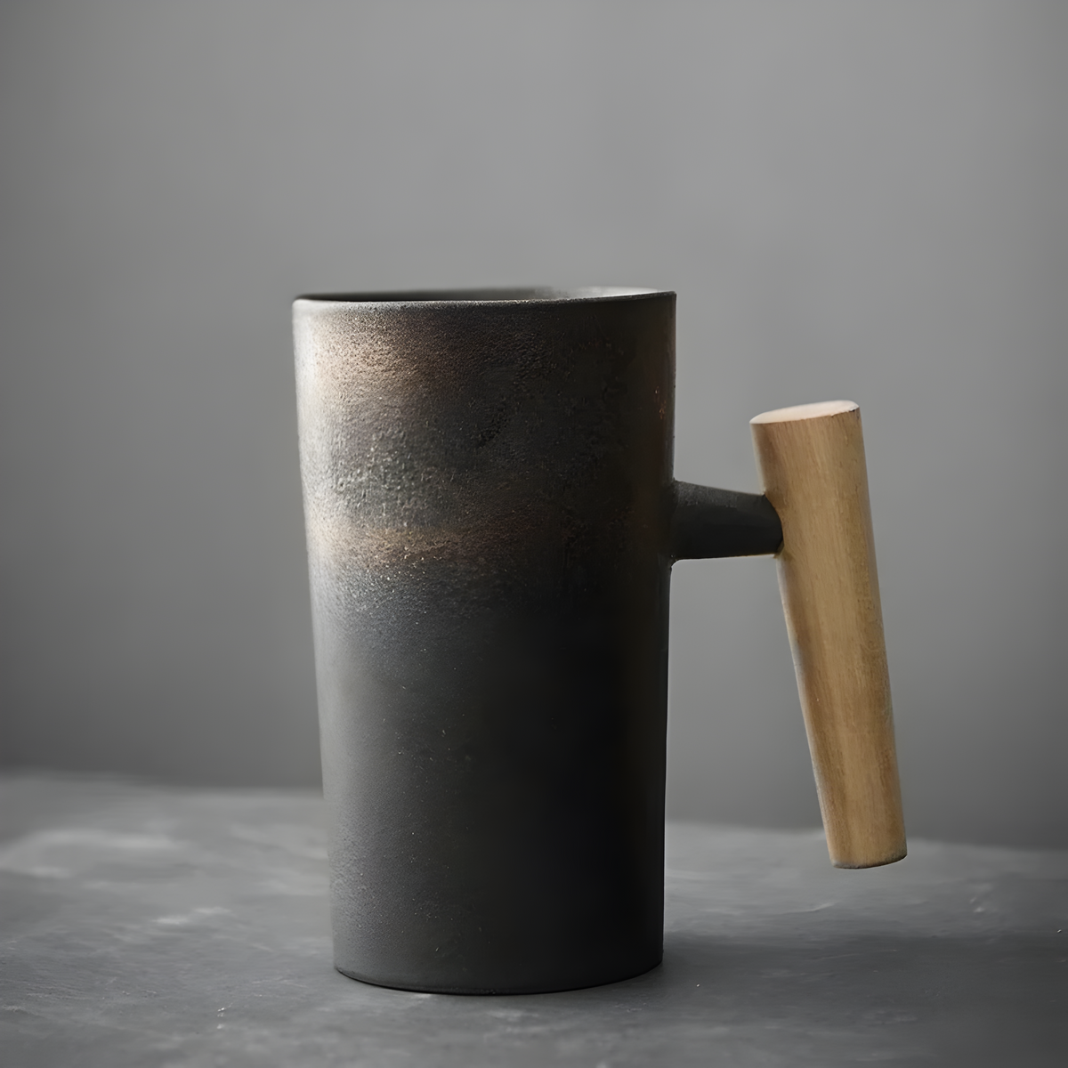 Svartgrå mugg med bronsskimrande övre del och ljust trähandtag 4