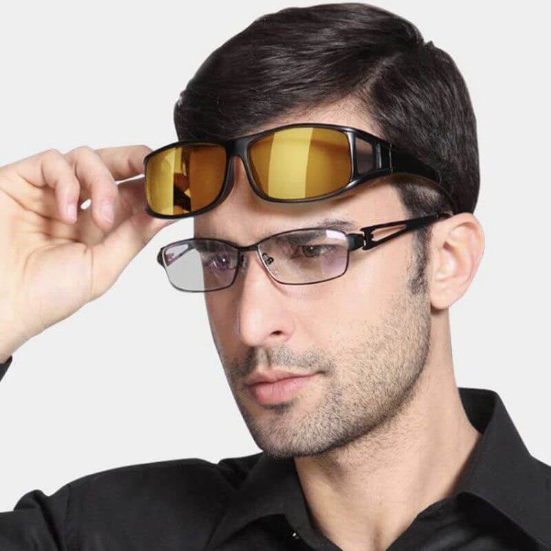 Mann mit Nachtsichtbrille, gelbe Gläser, schwarzer Rahmen, über normaler Brille, Nahaufnahme.