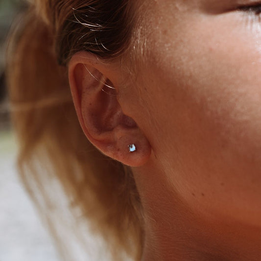 Nahaufnahme Ohr mit silbernem Perlenohrring, eleganter Schmuck, Damenaccessoire.