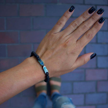Armband mit Lavastein-Perlen und Chevron-Muster, Aromatherapie, Handgelenk, Nahaufnahme.