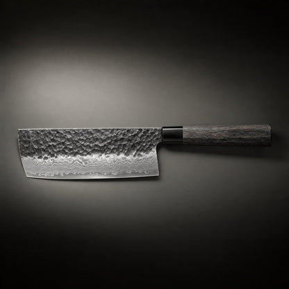 Kniven ligger vågrätt mot mörk bakgrund, sedd från sidan med hela det hamrade bladet, lagermönstret och träskaftet. 2