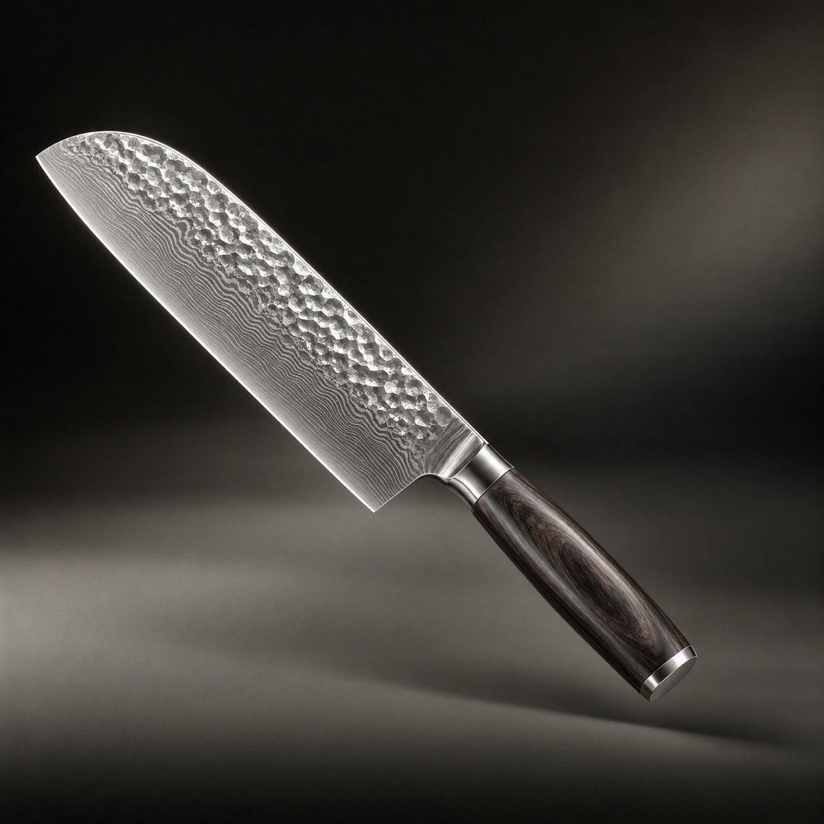 Kniv med hamrat, lagrat stålblad och mörkt träskaft, snett uppifrån mot mörk bakgrund 1