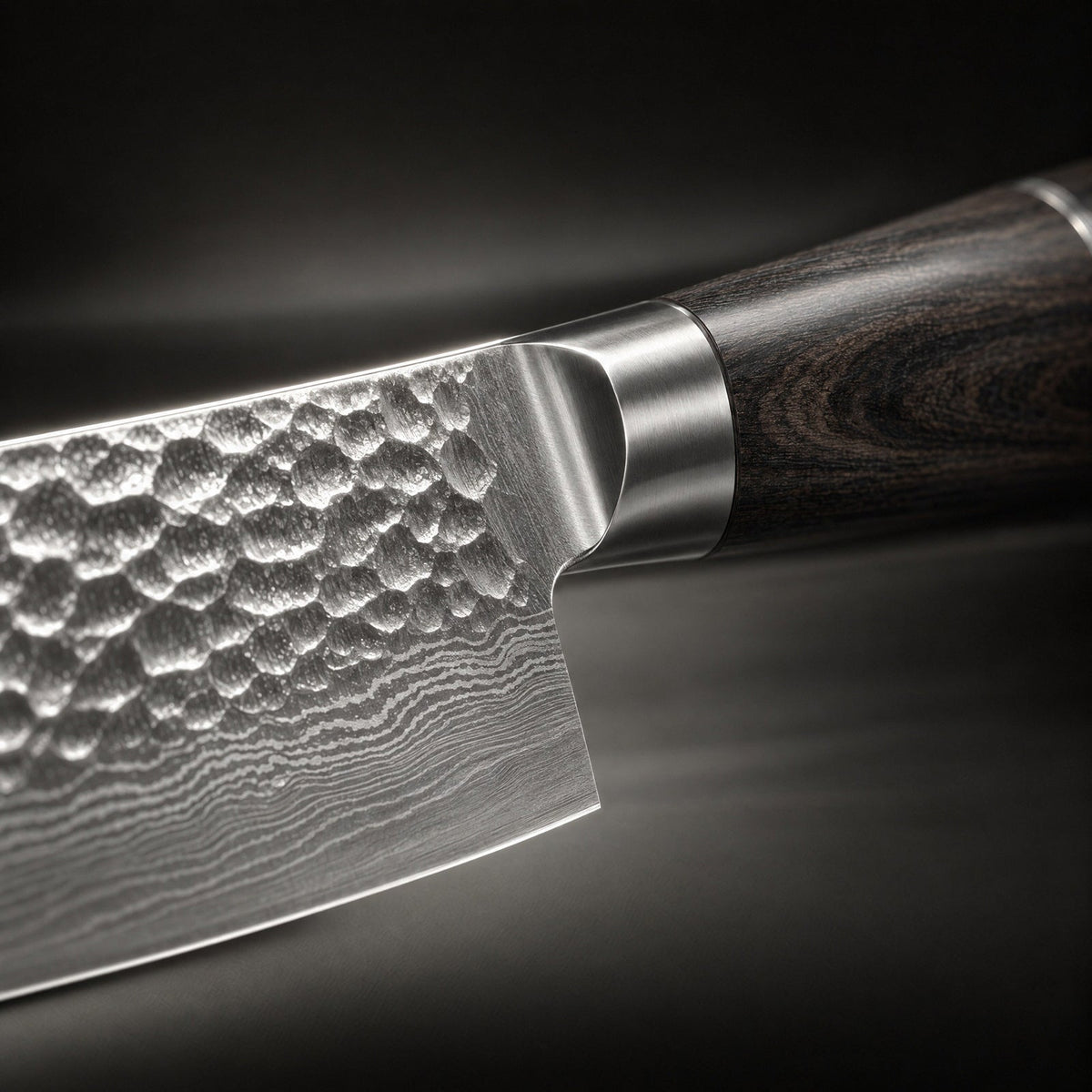 Närbild på övergången mellan bladets hamrade yta, metallkragen och skaftets mörka träådring 3