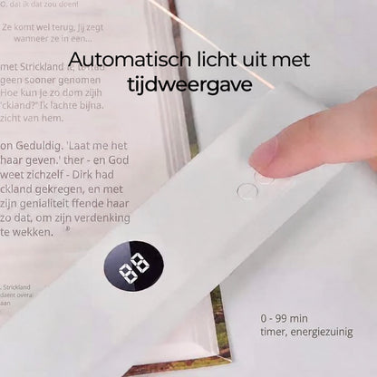 Ett finger trycker på knapparna vid displayen på lampan som ligger på en uppslagen bok 9