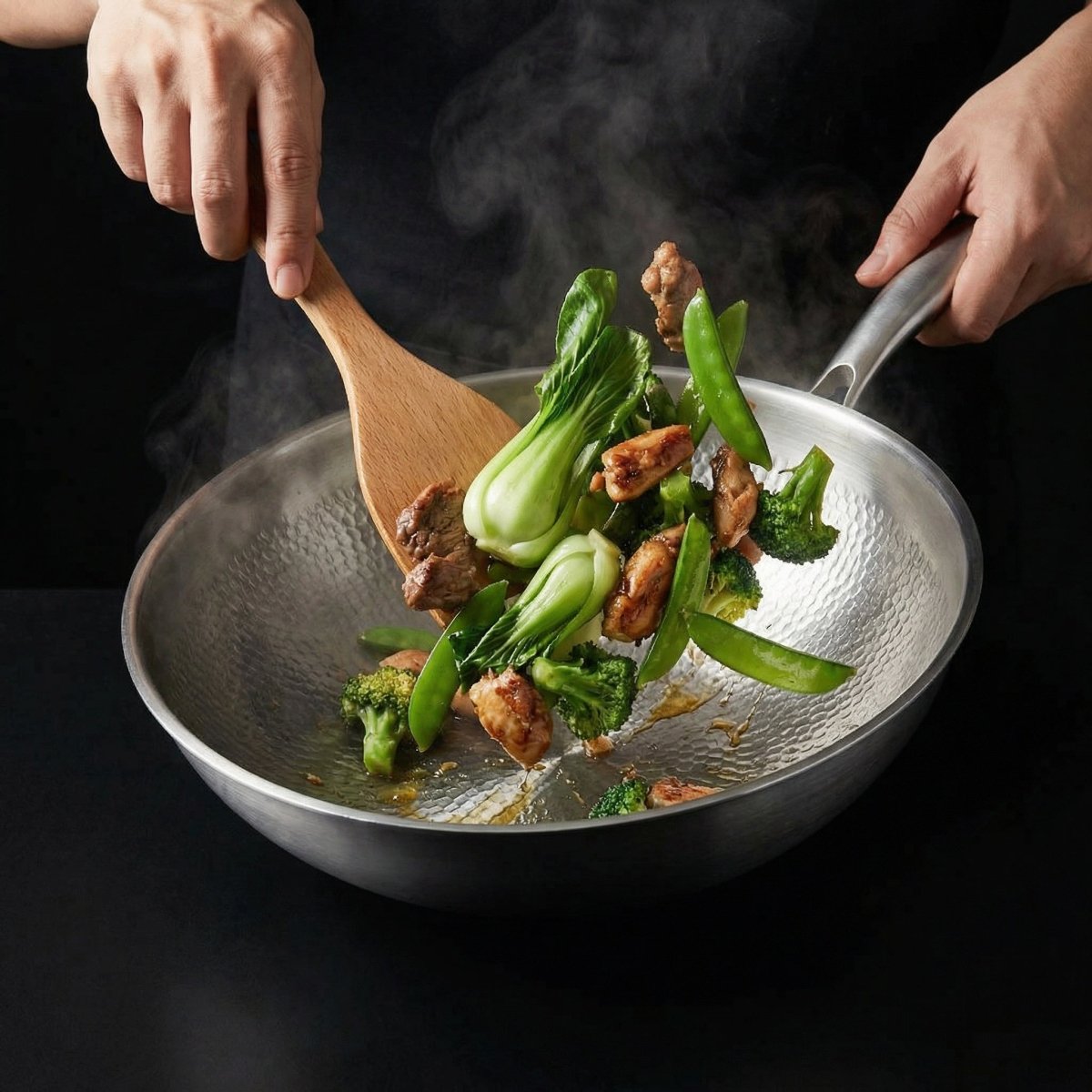 Två händer rör om kött, pak choi, broccoli och sockerärtor i wokpannan med en träspatel. 7