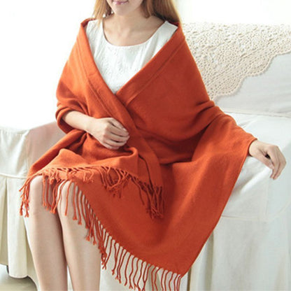 Frau mit orangefarbenem Schal aus Wolle, Fransen, gemütlich, modisch, Herbst-Winter-Accessoire.