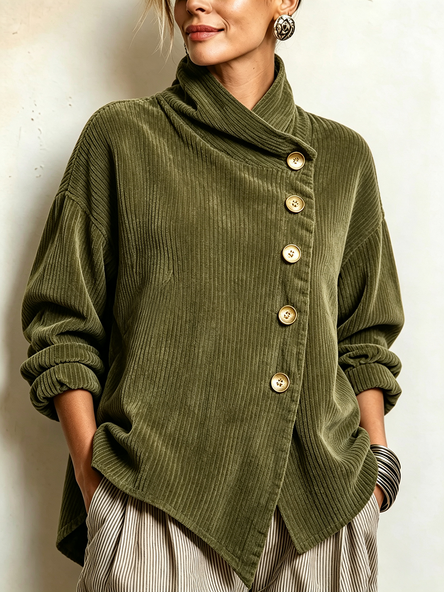 Närbild framifrån på grön manchestertröja med sneda knappar och hög krage, buren av modell med händerna i fickorna. 1
