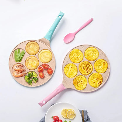 Zwei Pfannkuchenpfannen mit bunten Griffen, gefüllt mit Omeletts und Gemüse, auf weißem Hintergrund.