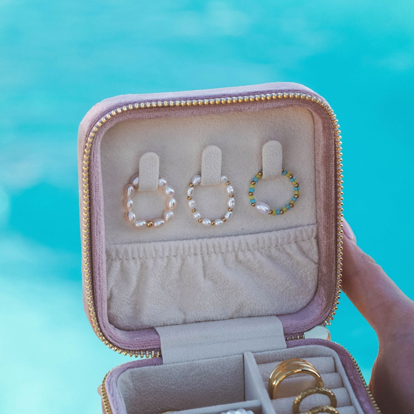 Perlenringe in Schmuckbox vor blauem Hintergrund, eleganter Schmuck, stilvolle Accessoires.