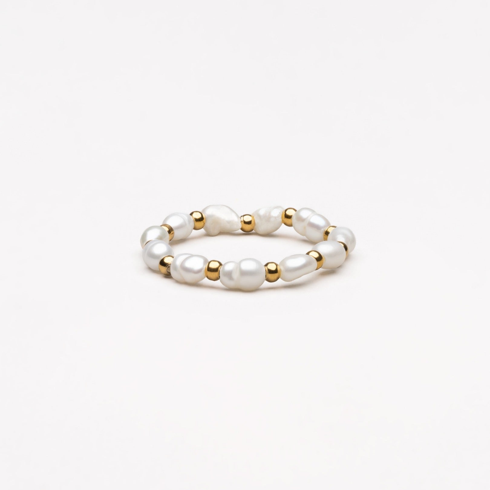 Perlenring mit goldenen Akzenten, eleganter Schmuck, weiß, modisch, Damenaccessoire.