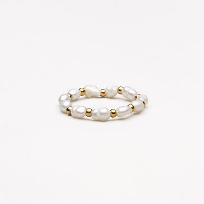 Perlenring mit goldenen Akzenten, eleganter Schmuck, weiß, modisch, Damenaccessoire.