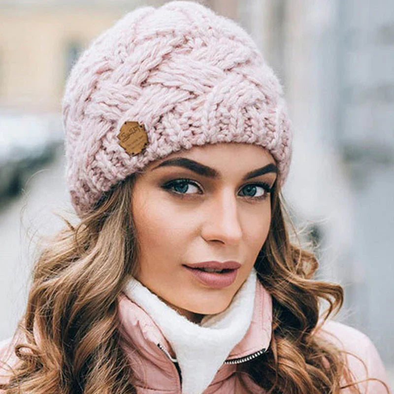 Frau mit rosa Strickmütze, Zopfmuster, Wintermode, warm, stilvoll, draußen, Stadtumgebung.