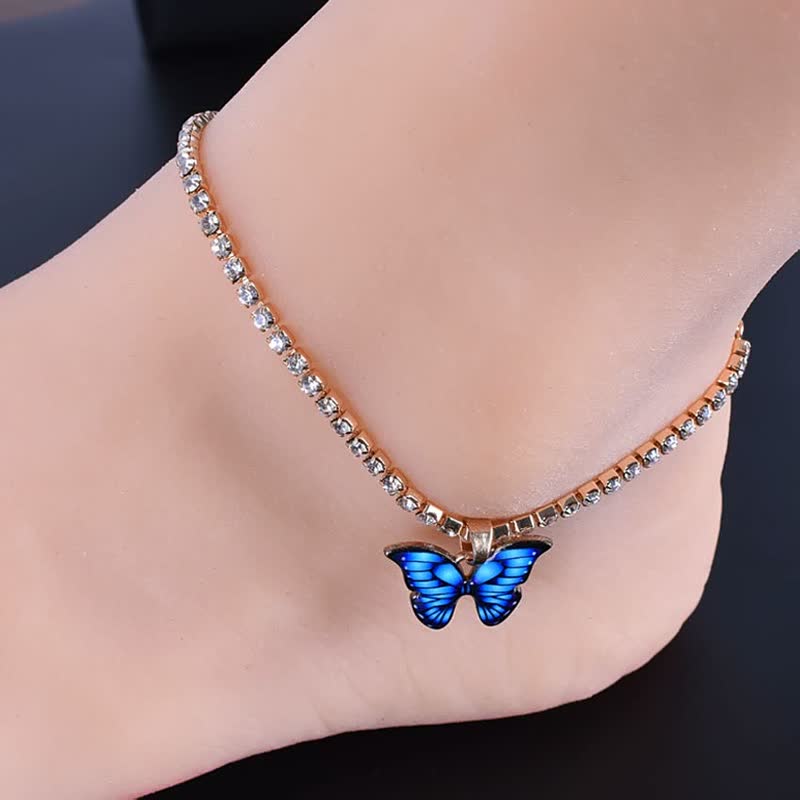 Goldenes Fußkettchen mit blauen Schmetterlingsanhänger, Strasssteine, modisches Schmuckaccessoire.
