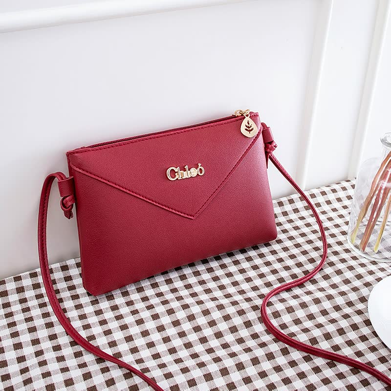 Rote Damenhandtasche aus Leder mit Schulterriemen, elegantes Design, goldene Akzente.