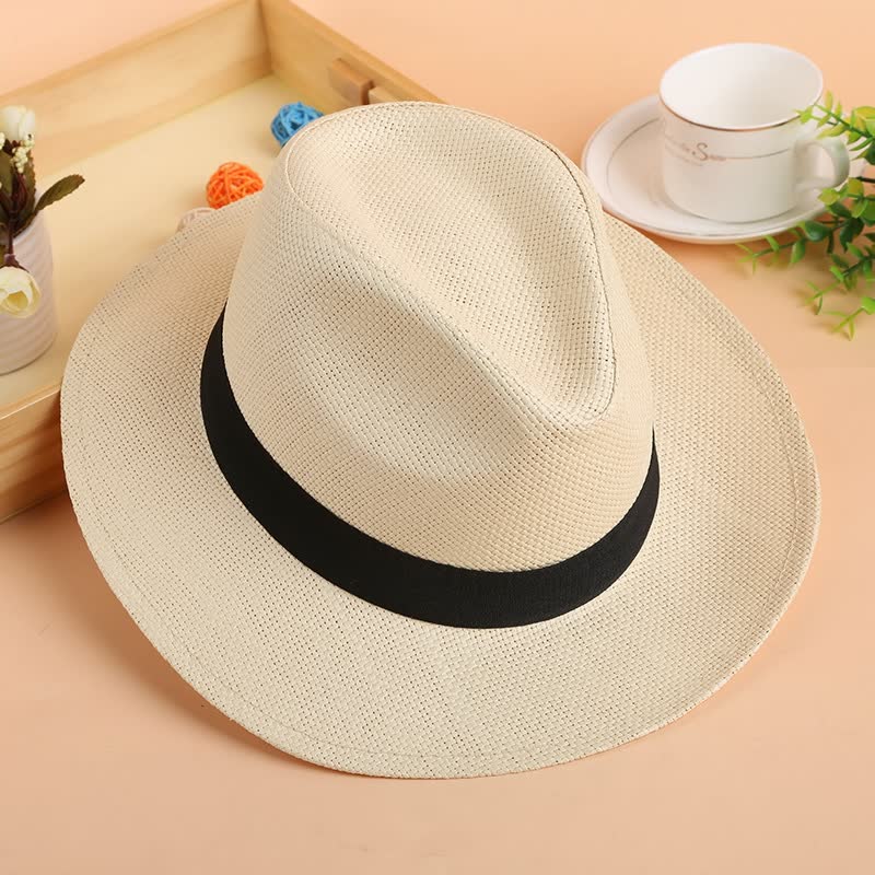 Beiger Fedora-Hut aus Stroh mit schwarzem Band, ideal für Sommermode und Sonnenschutz.