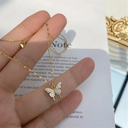 Goldene Schmetterlingskette mit Strasssteinen, elegantes Schmuckstück auf Hand präsentiert.