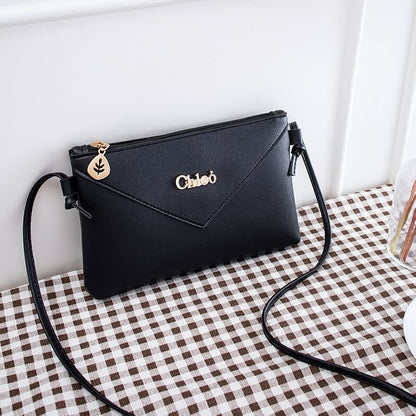 Schwarze Lederhandtasche mit Schulterriemen, goldener Reißverschluss, elegantes Design.