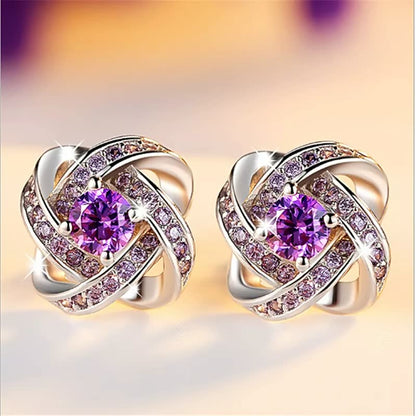 Goldene Ohrringe mit violetten Kristallen, funkelnd, elegantes Schmuckdesign, Damenaccessoire.