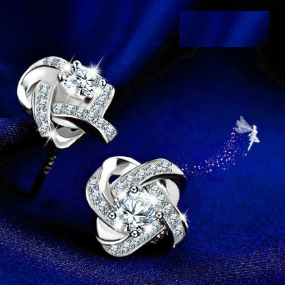 Silberne Ohrringe mit Zirkonia, funkelnd, auf blauem Hintergrund, eleganter Schmuck.