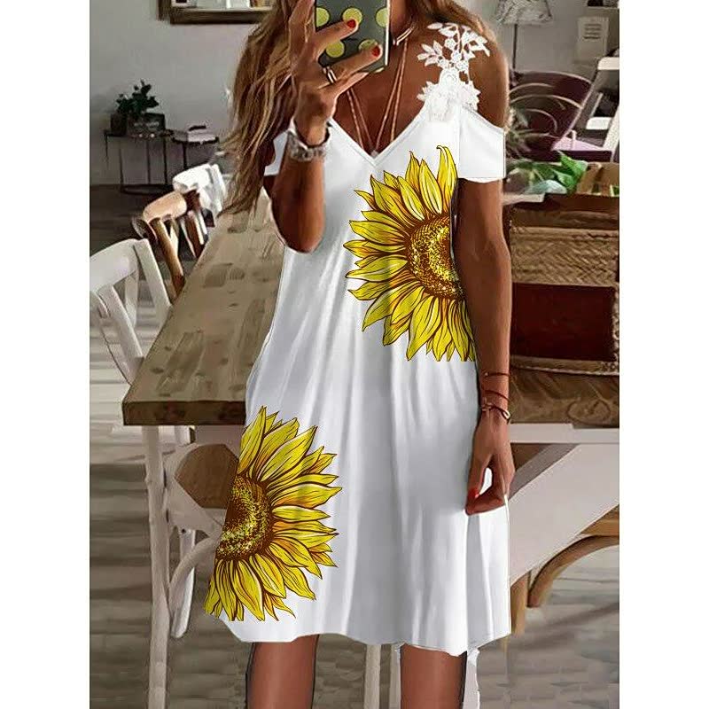 Frau in weißem Sommerkleid mit Sonnenblumenmuster, schulterfrei, modisch, lässig.