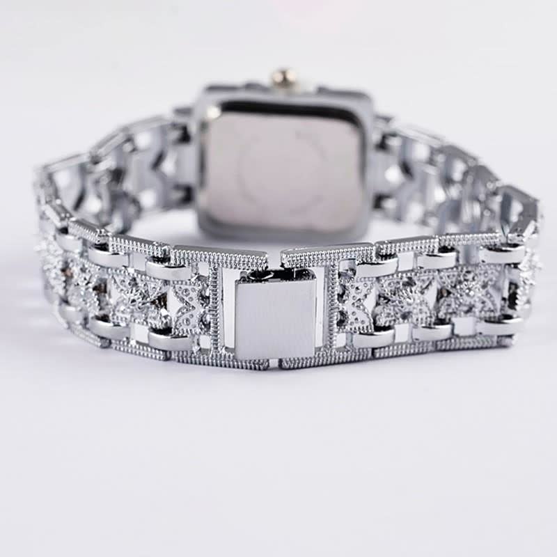 Silberne Armbanduhr mit quadratischem Zifferblatt und verziertem Gliederarmband, luxuriöses Design.