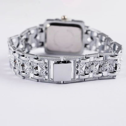Silberne Armbanduhr mit quadratischem Zifferblatt und verziertem Gliederarmband, luxuriöses Design.