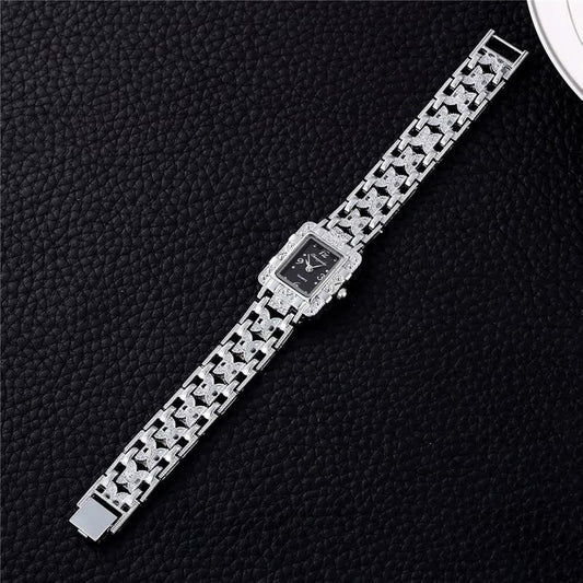 Luxus-Damenuhr mit silbernem Armband und schwarzem Zifferblatt auf schwarzem Hintergrund.