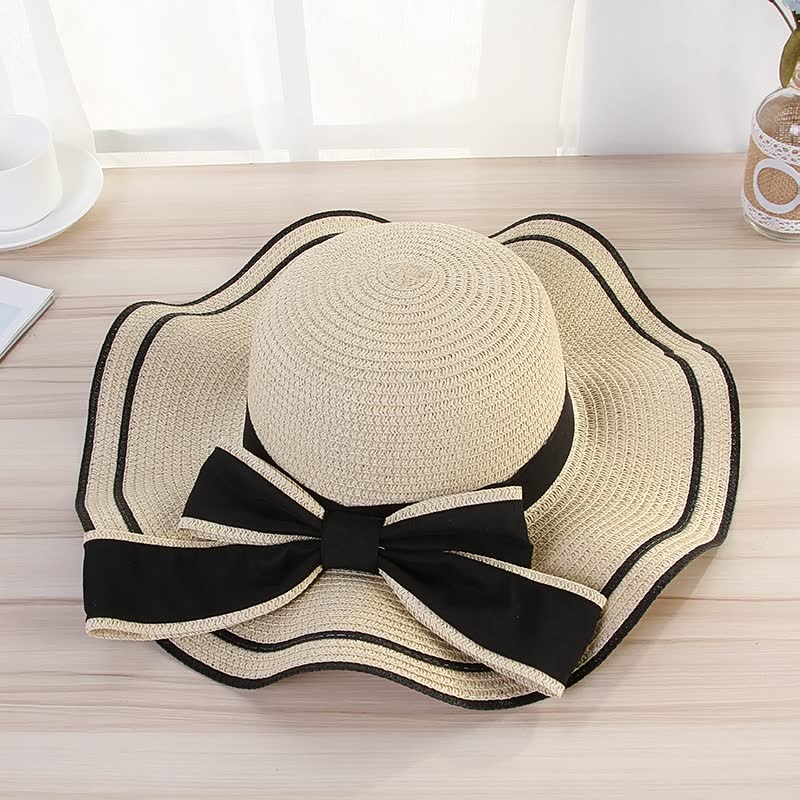 Beiger Damen-Sonnenhut mit schwarzer Schleife, elegantes Design, ideal für Sommermode.
