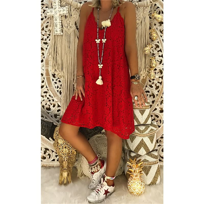 Frau in rotem Spitzenkleid, Boho-Stil, mit weißen Sneakers und langen Halsketten.