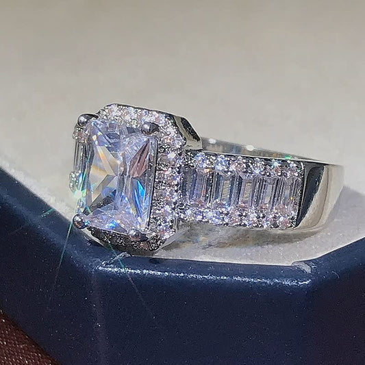 Silberner Verlobungsring mit quadratischem Diamant und Pavé-Fassung, funkelnd, elegant.