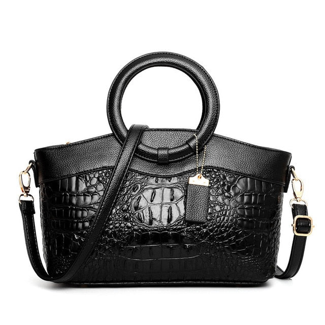 Schwarze Krokodilleder-Handtasche mit Rundgriffen und verstellbarem Schulterriemen.