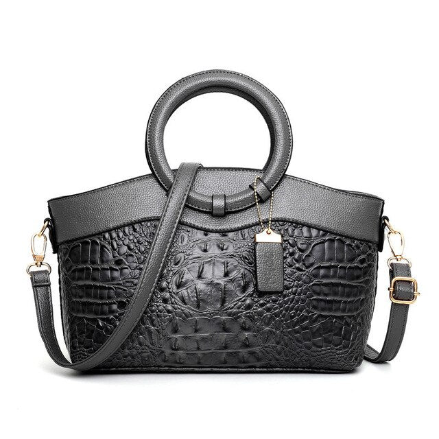 Luxuriöse schwarze Krokodilleder-Handtasche mit rundem Griff und abnehmbarem Schulterriemen.