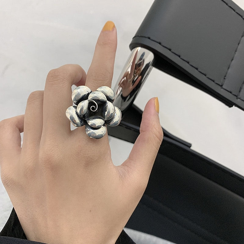 Silberner Blumenring auf Hand, modisches Accessoire, elegantes Design, Damenring.