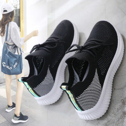 Schwarze Damen-Sneaker mit weißer Sohle, atmungsaktives Mesh, ideal für Freizeit und Sport.