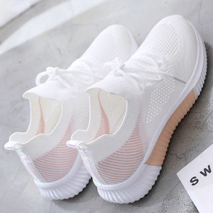 Weiße Sportschuhe aus Mesh mit Gummisohle auf grauem Hintergrund, modisch und atmungsaktiv.