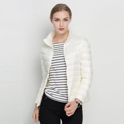 Frau in weißer Daunenjacke, gestreiftem Shirt, schwarze Hose, modisch, Winterbekleidung.