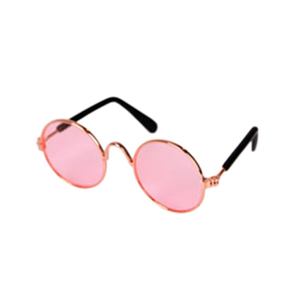 Runde Sonnenbrille mit rosa Gläsern und goldfarbenem Rahmen, modisches Accessoire.