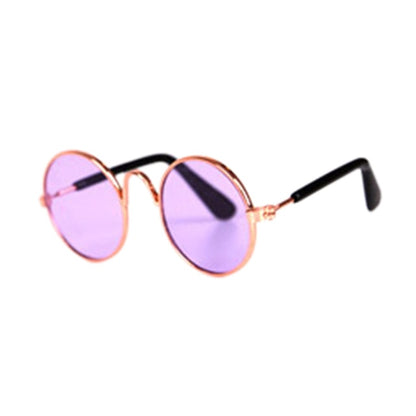 Runde Sonnenbrille mit rosa Gläsern und goldfarbenem Rahmen, modisches Accessoire.