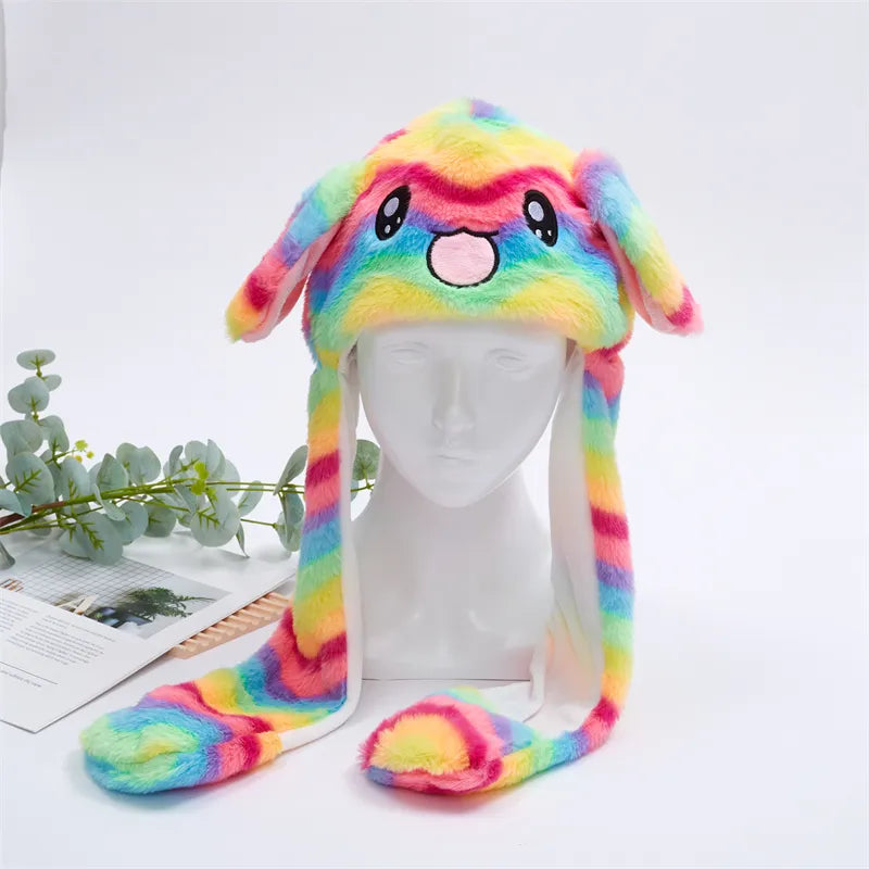 Bunte Plüsch-Hasenmütze mit Regenbogenmuster, Ohrenklappen und niedlichem Gesicht.