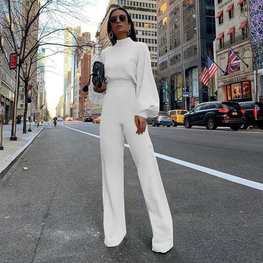 Frau in weißem Jumpsuit mit Stehkragen auf Stadtstraße, modisch, elegant, urbaner Stil.