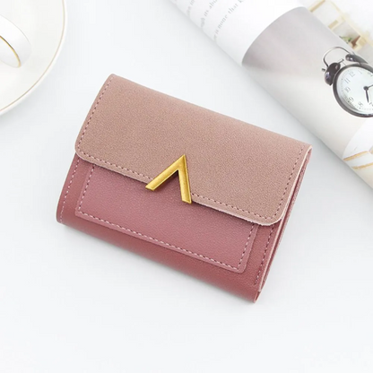 Rosa Damen-Geldbörse aus Leder mit goldener Verzierung, kompakt und elegant.