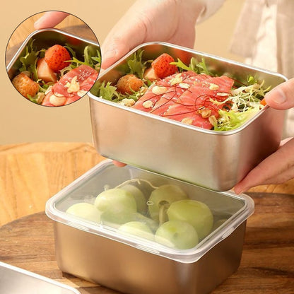 Händer lyfter en burk med sallad och laxskivor ovanför en annan burk med gröna druvor under genomskinligt lock, med utsnitt av maten. 1