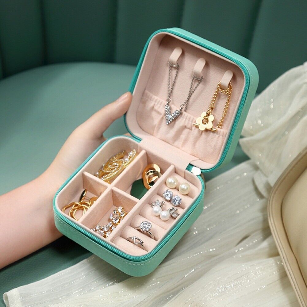 Türkisfarbene Schmuckbox mit Fächern, enthält goldene und silberne Schmuckstücke, ideal für Reisen.