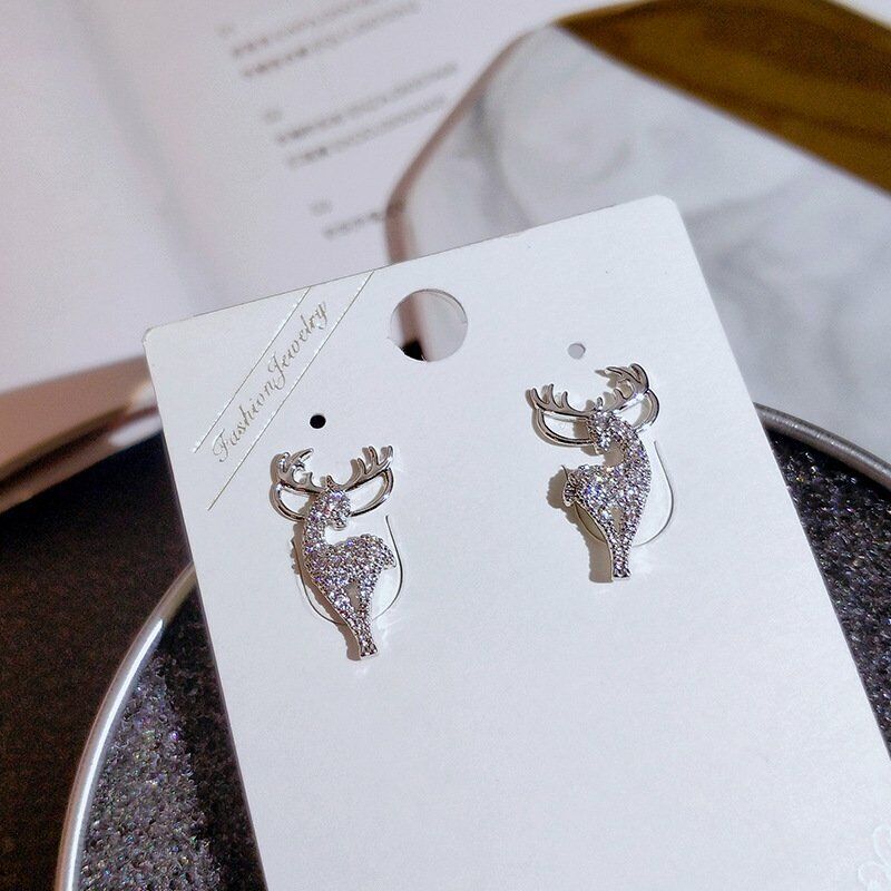 Silberne Hirsch-Ohrringe, funkelnd, modisch, auf weißer Karte, eleganter Schmuck.