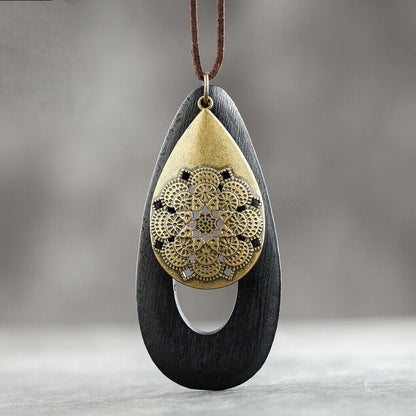 Schwarze Holz-Halskette mit goldener Mandala-Anhänger, handgefertigter Schmuck, Boho-Stil.
