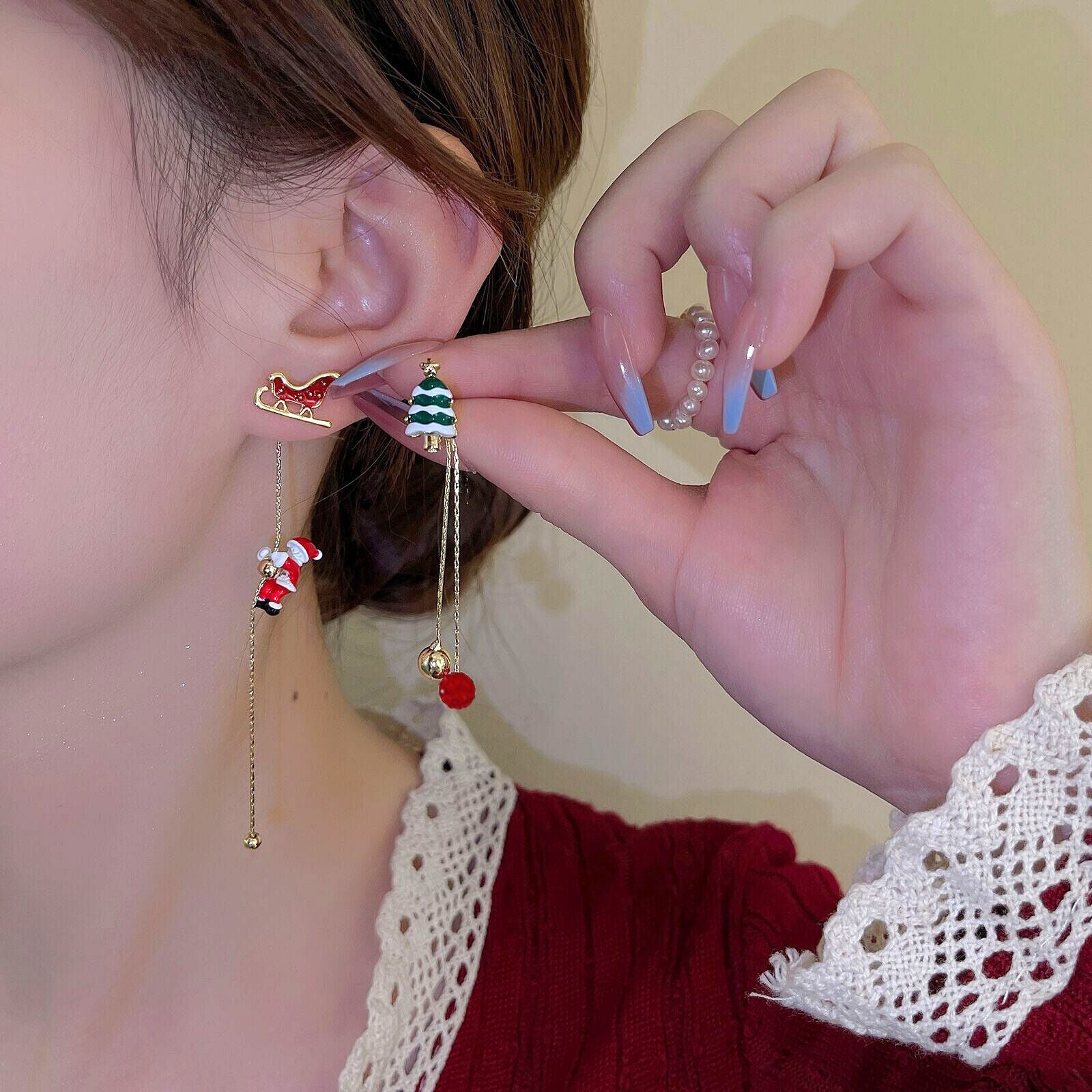 Frau mit Weihnachts-Ohrringen, Schlitten und Tannenbaum-Design, goldene Kette, festlicher Schmuck.