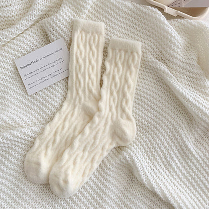 Beige Wollsocken auf gestricktem Hintergrund, warme Wintermode, gemütliche Accessoires.