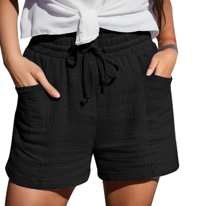Frau in schwarzer Baumwollshorts mit Taschen und weißem Oberteil, Sommermode.